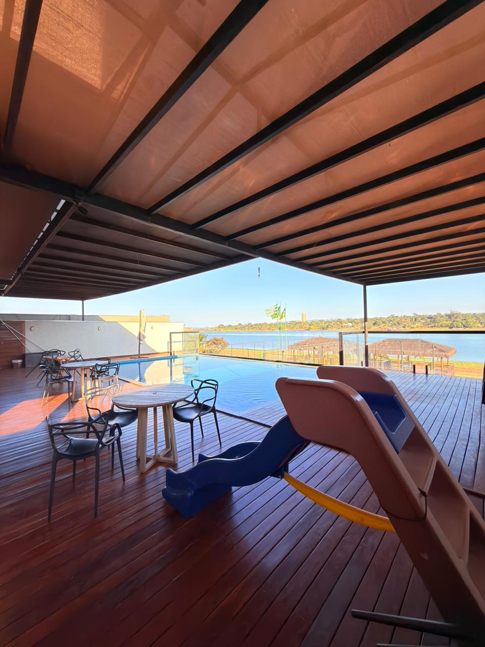Deck coberto com piscina infinity ao entardecer